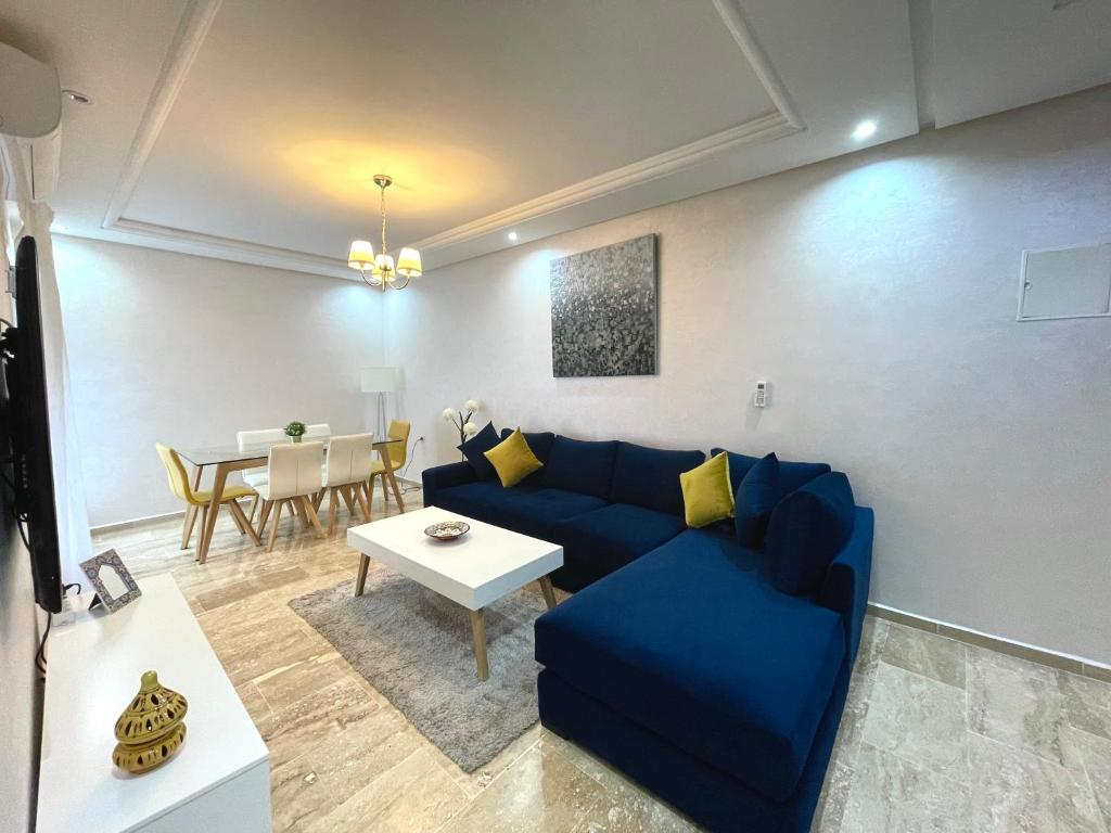 a living room with a blue couch and a table at Appartement Tanger Moulay Ismail in Tangier