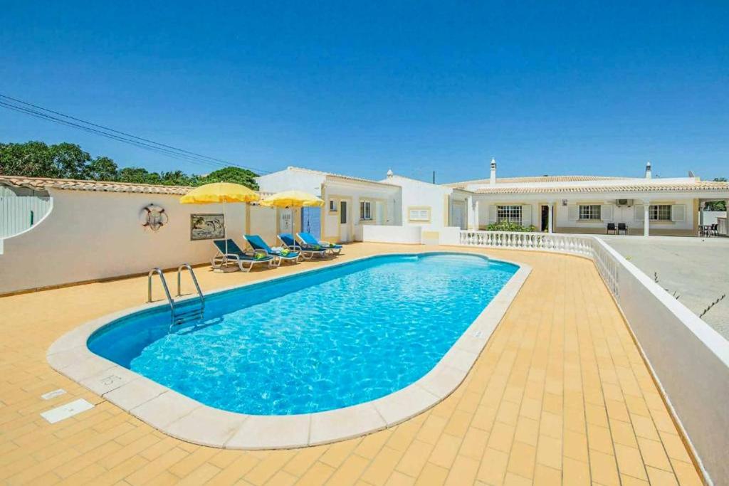 a swimming pool in front of a house at Casa Luz in Lagoa