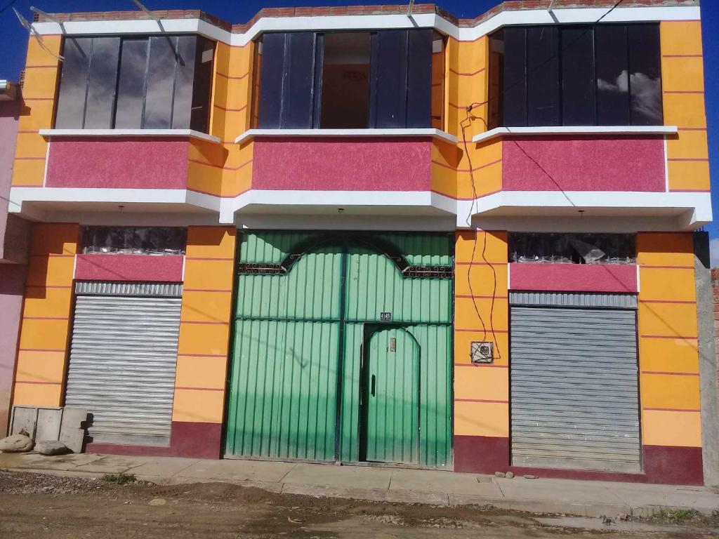 um edifício colorido com uma porta verde em Casas Kevin em Mojón de Achocalla