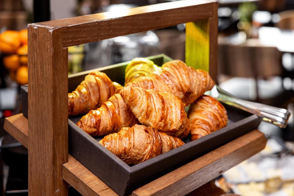 a tray of croissants and other pastries on a stand at Hotel Indigo - Edinburgh - Princes Street by IHG in Edinburgh