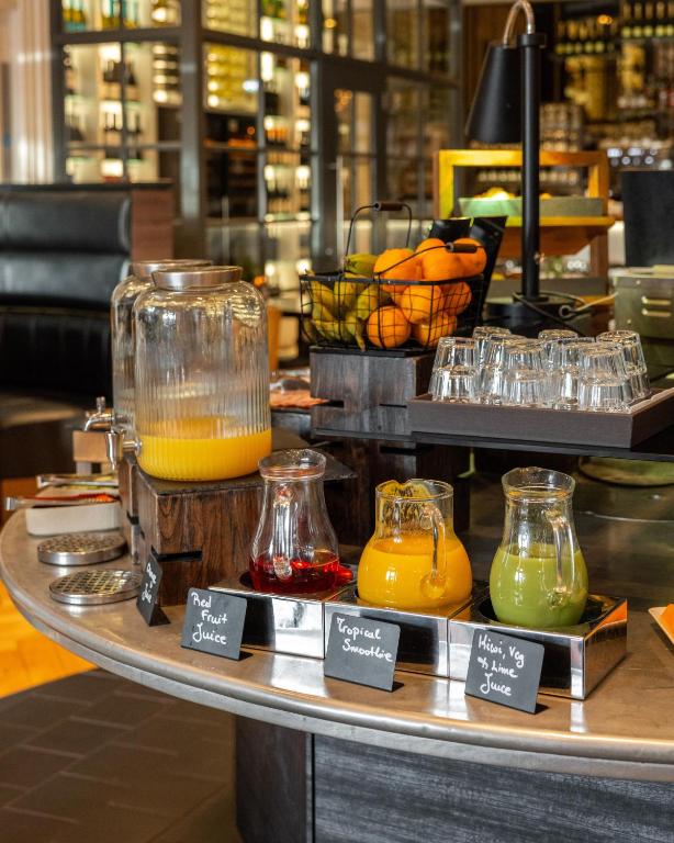 a table with different types of juice on it at Hotel Indigo - Edinburgh - Princes Street by IHG in Edinburgh