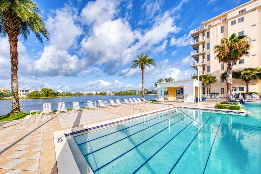 una piscina frente a un edificio con palmeras en Carillon Beach Resort Inn en Panama City Beach
