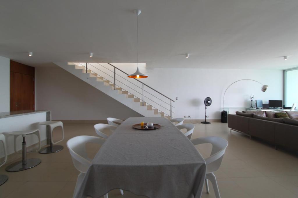a dining room with a table and chairs and a staircase at Rooftop Penthouse and Loft in Nueva Gorgona
