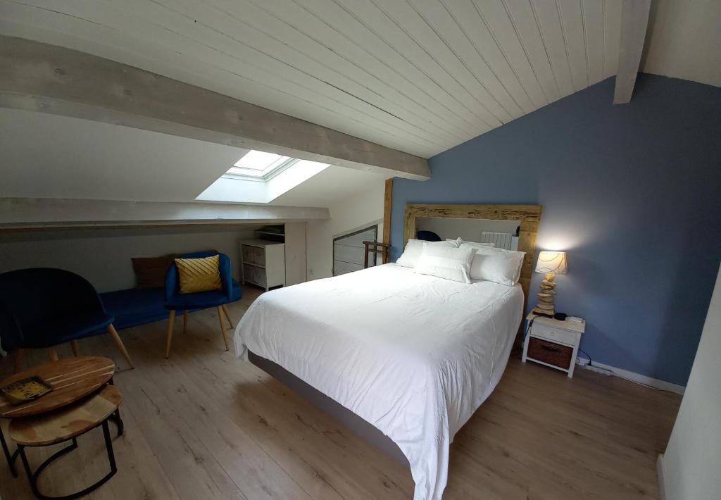 um quarto com uma cama branca e uma parede azul em Ty'Château Carignan de Bordeaux B&B em Carignan