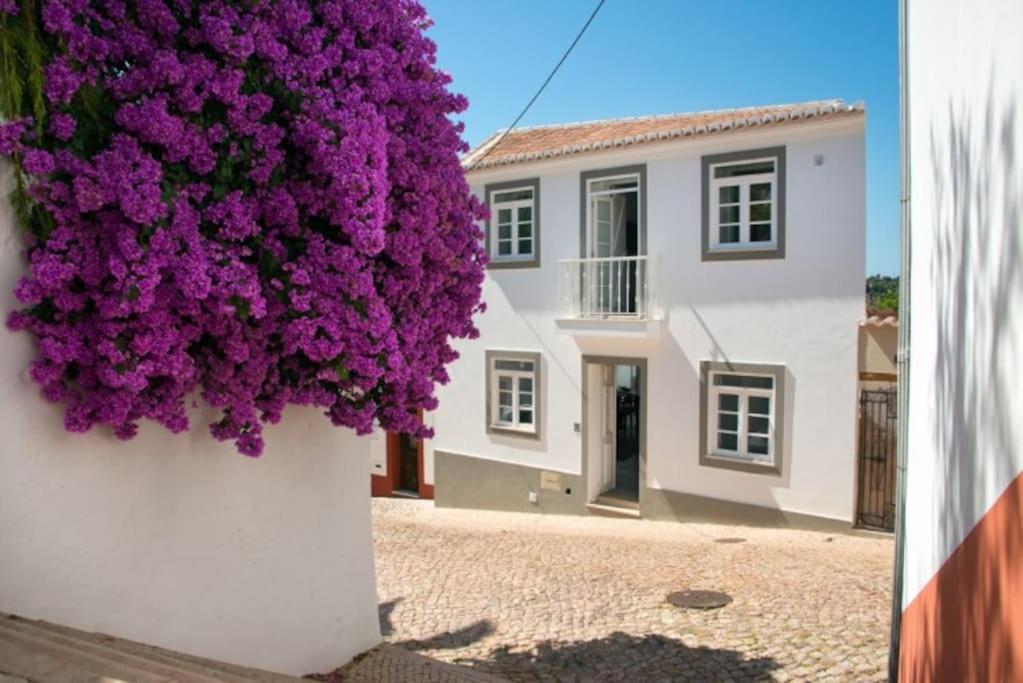 a white house with purple flowers on the side of it at Stylish town house in Silves in Silves