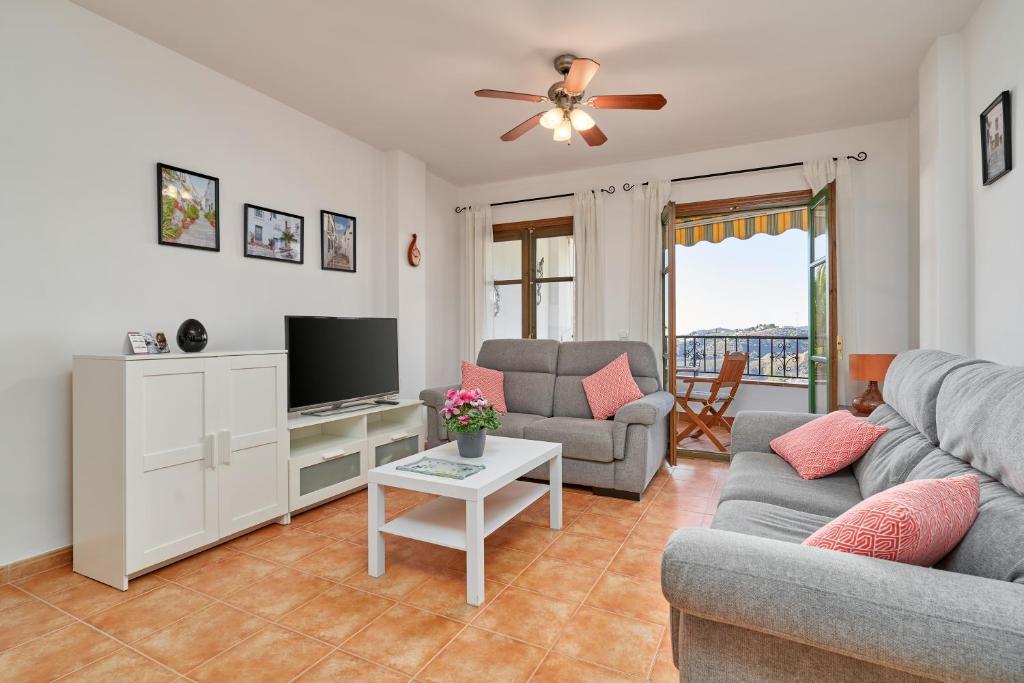 a living room with a couch and a tv at Casa Ella in Frigiliana