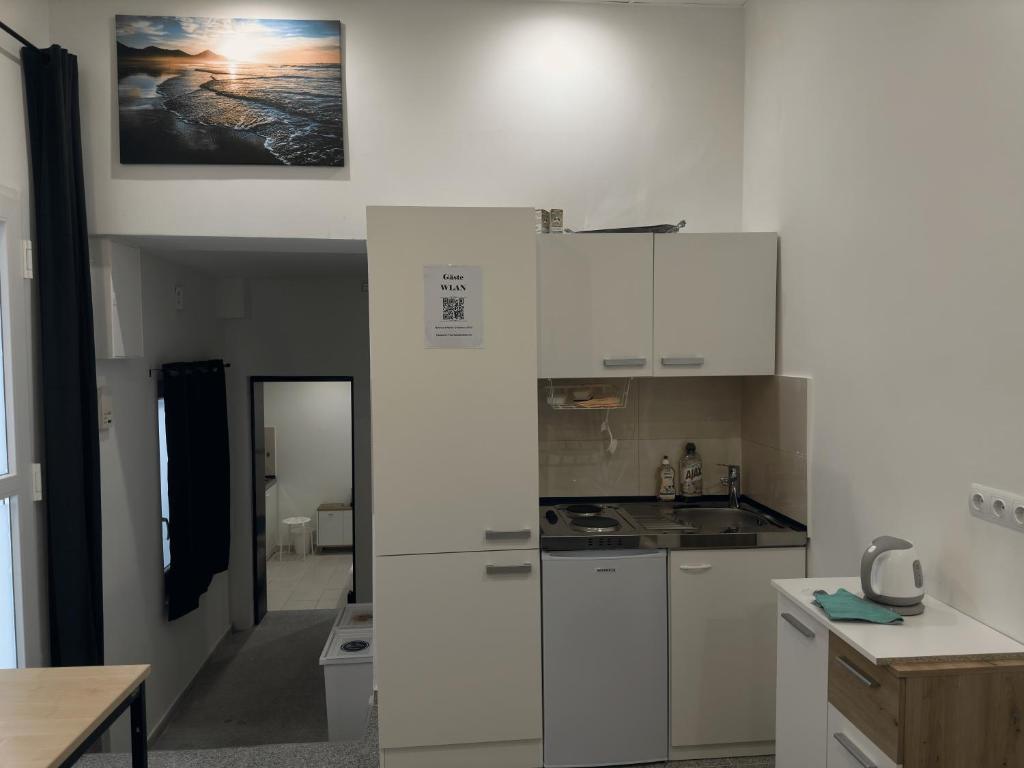 - une cuisine blanche avec des placards blancs et une table dans l'établissement MK Apartments Bremen 1, à Brême