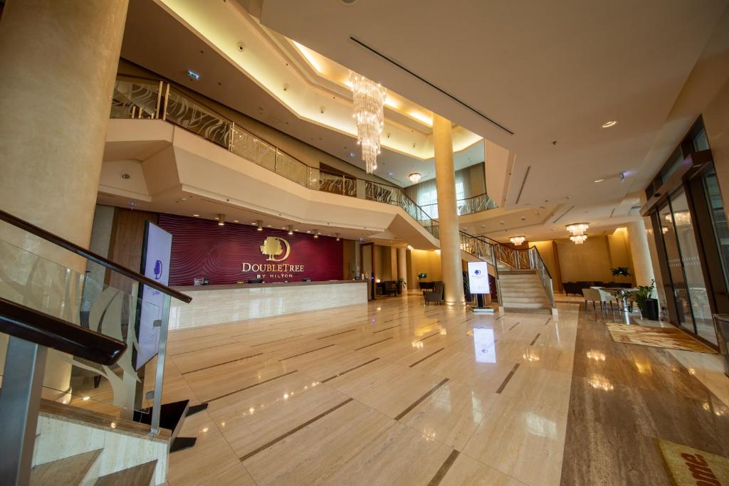 eine große Lobby mit Holzboden in einem Gebäude in der Unterkunft DoubleTree by Hilton Bratislava in Bratislava