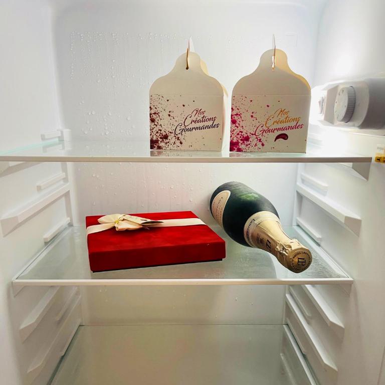 a refrigerator with a gift and a bottle of champagne at Villa Red Palmer -sauna jacuzzi in Gros-Morne