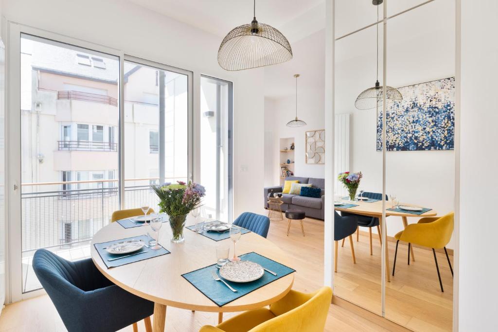 une salle à manger et un salon avec une table et des chaises dans l'établissement Le Terre Neuve - Grande plage du sillon, à Saint-Malo