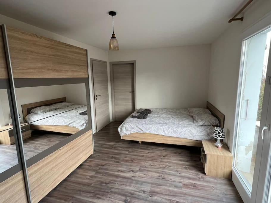 sypialnia z 2 łóżkami i dużym lustrem w obiekcie House Near EPFL/Unil/Renens Gare/Lausanne w mieście Ecublens
