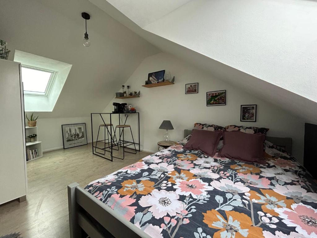 una camera da letto con un letto con copriletto floreale di CHAMBRE PRIVÉE dans une maison ad Argenteuil