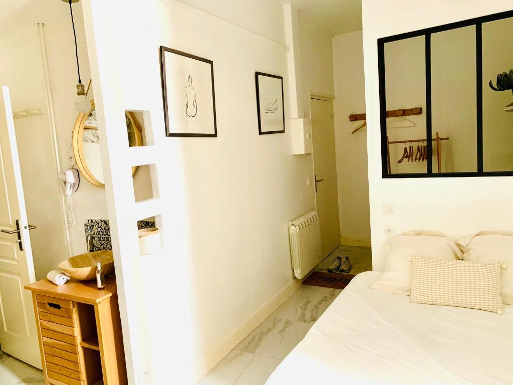 - une chambre blanche avec un lit et un miroir dans l'établissement New Suite & SPA - Cannes Centre - Croisette, à Cannes