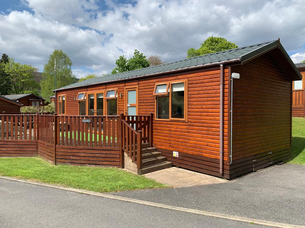 a small wooden cabin with a wooden fence at Mon Reve in Windermere