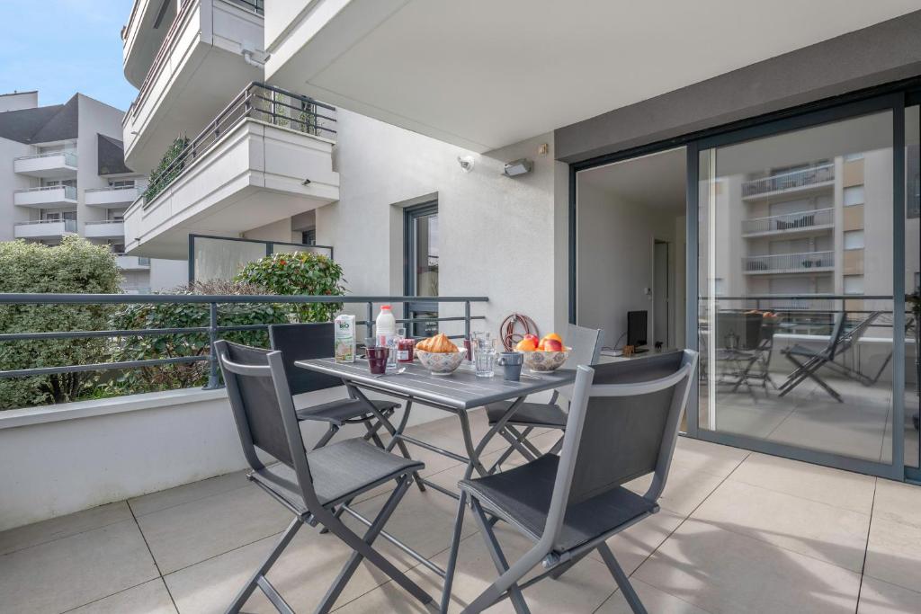 - une table et des chaises sur le balcon d'un appartement dans l'établissement Virée au Pouliguen à 150m du port, au Pouliguen