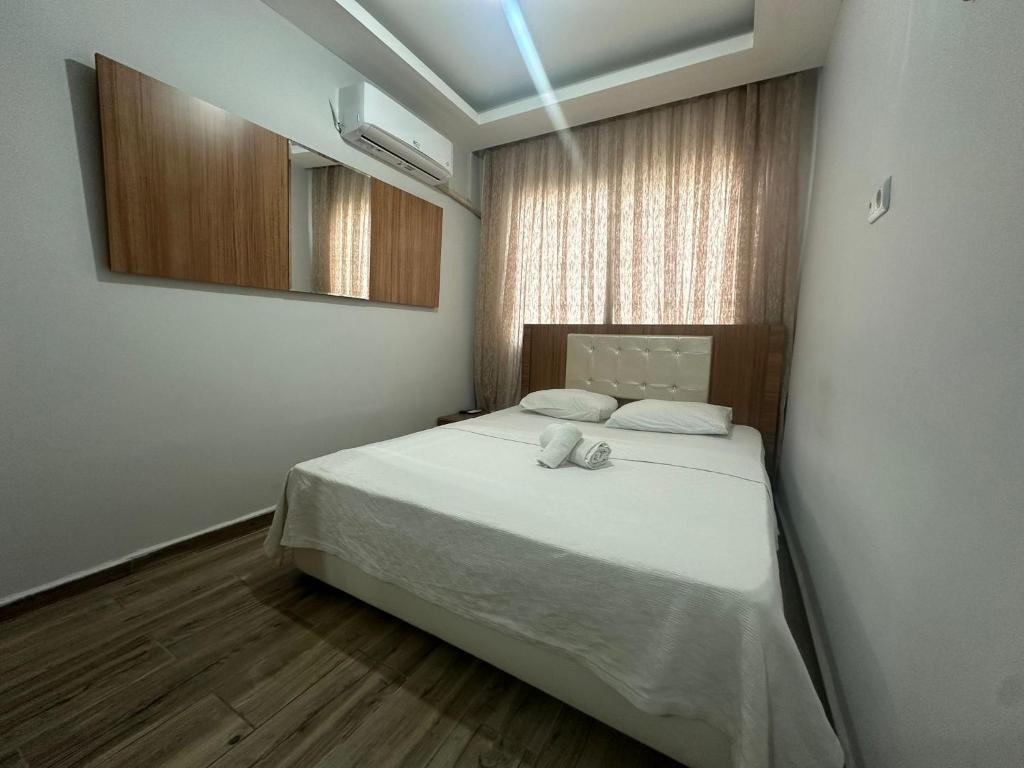 a bedroom with a white bed with a mirror at DİAMOND PALACE APART HOTEL in Hatay