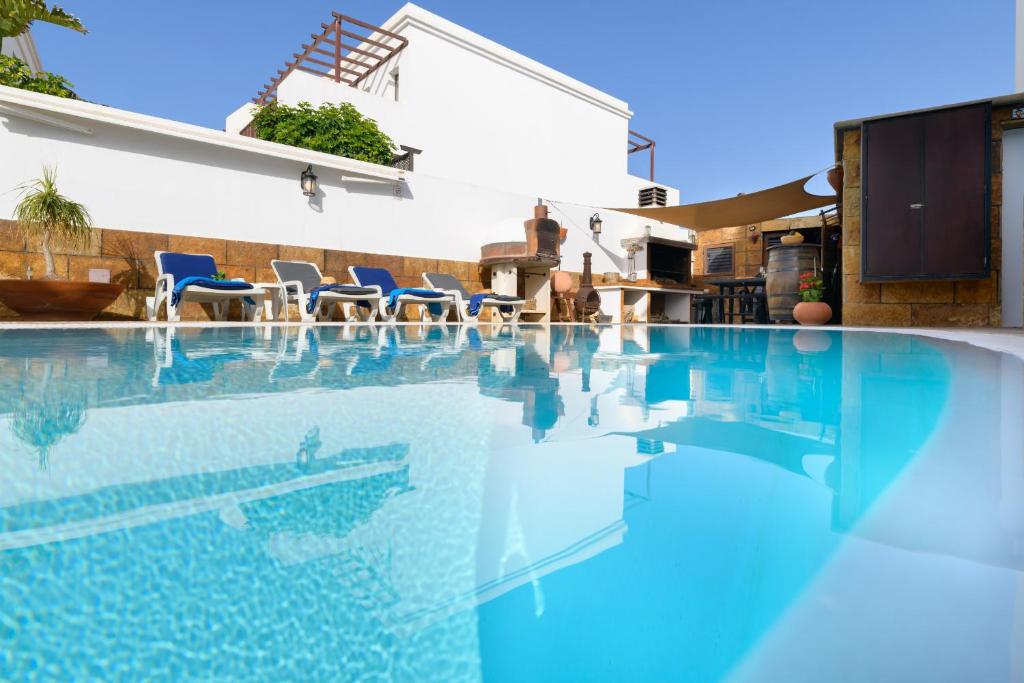 una piscina con sillas y una casa en Casa Kesa, el Rincon de Juan, en Tías