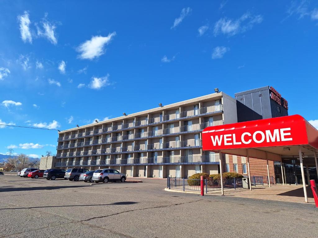 una señal de bienvenida frente a un edificio en American Motel en Wheat Ridge