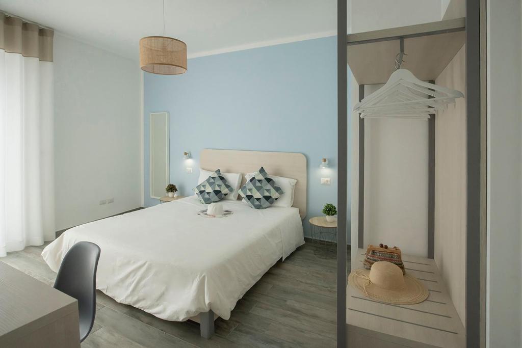 um quarto com uma cama branca e um espelho em Dimora del Corso - Rooms em Mattinata