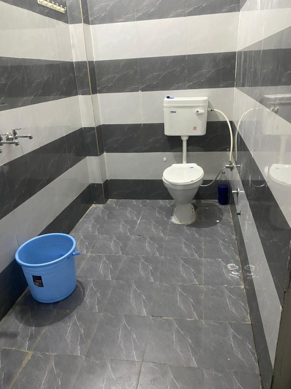 y baño con aseo, lavamanos y cubo. en Grewal homestay, en Jalandhar