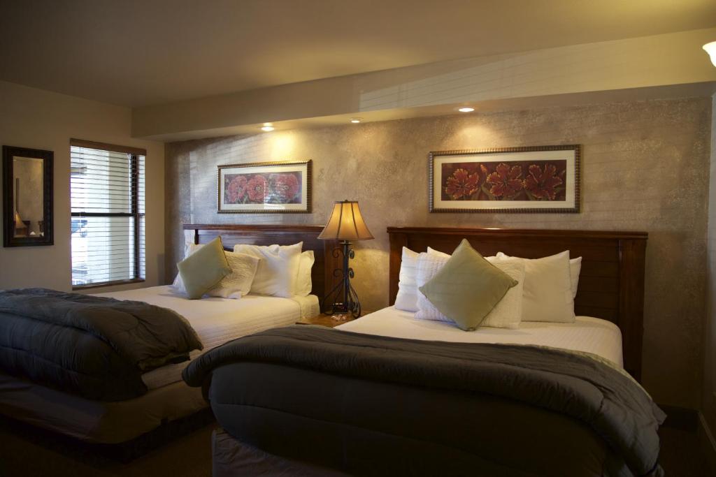 una camera d'albergo con due letti e una lampada di The Lodge on Route 66 a Williams