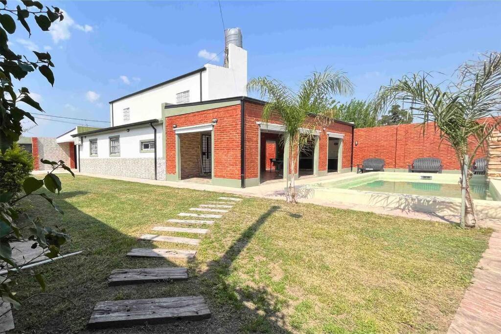 uma casa de tijolos com piscina no quintal em Acogedor alojamiento con piscina y gran patio em La Guardia