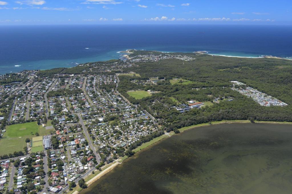 an aerial view of a city next to the ocean at Canton Beach Holiday Park in Toukley