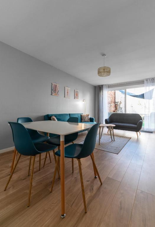 - un salon avec une table, des chaises et un canapé dans l'établissement L'Eugène - Maison 3 chambres, à Vichy
