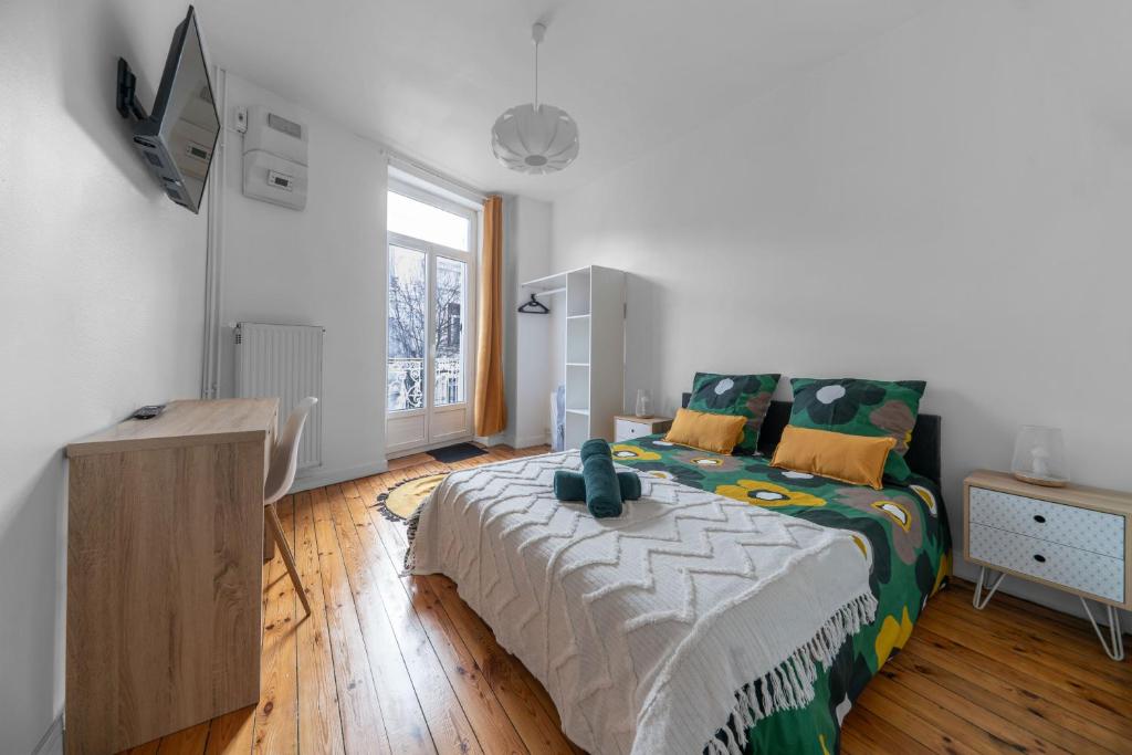 ein Schlafzimmer mit einem Bett und einem TV in der Unterkunft L'Eugène - Maison 3 chambres in Vichy