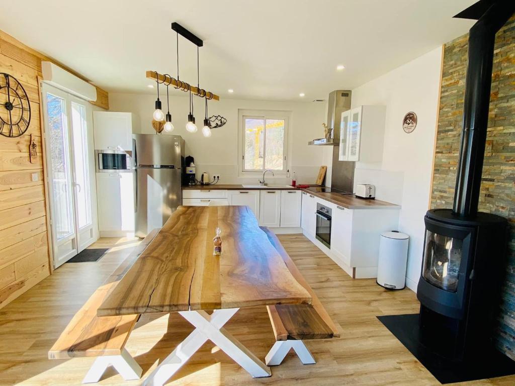 una cocina con una mesa de madera en el medio. en Les Refuges Ariégeois, en Ax-les-Thermes