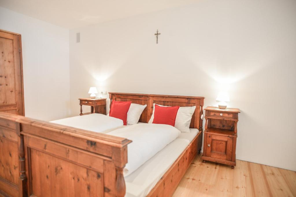 - une chambre avec 2 lits et des oreillers rouges dans l'établissement Tholer Ferienwohnung 2, à Lagundo