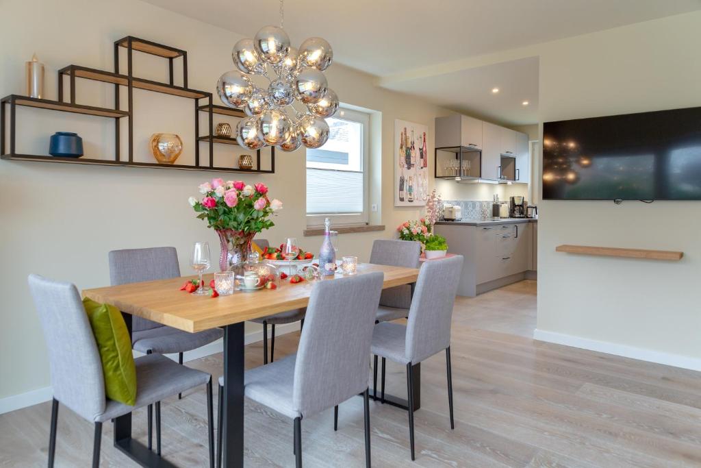 a dining room table with chairs and a chandelier at Family Hüs in Westerland (Sylt)
