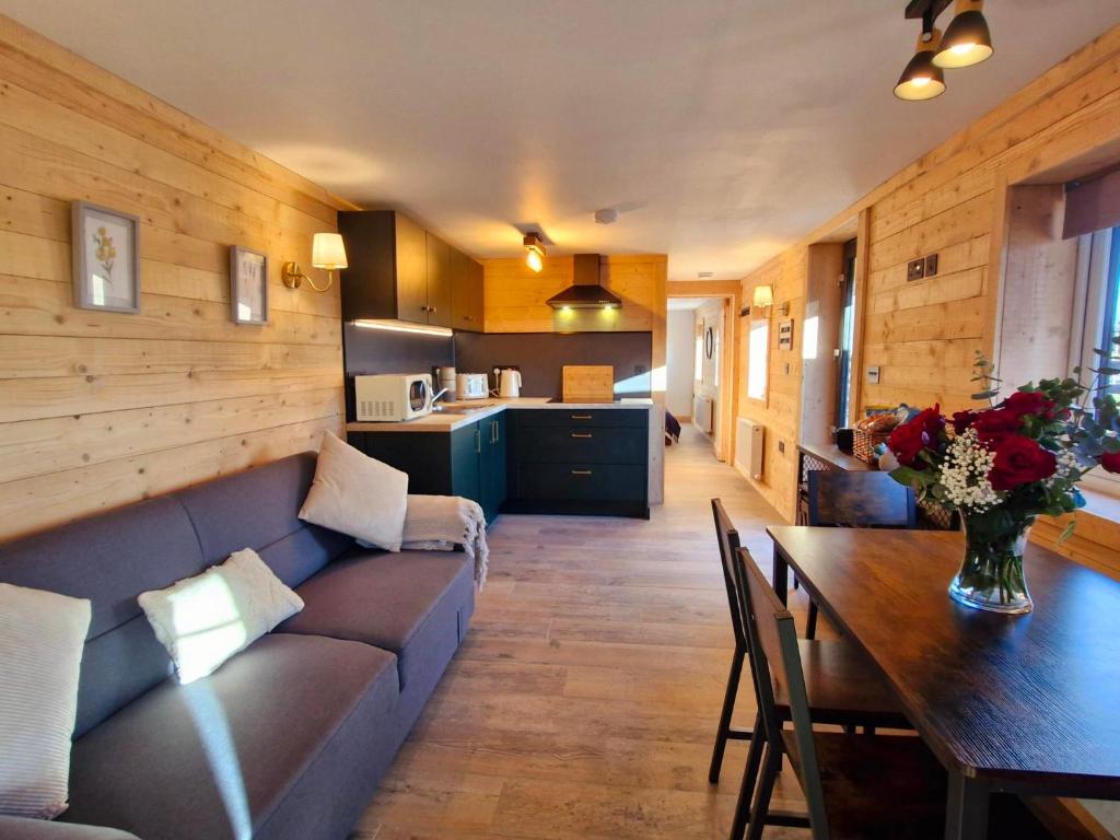 a living room with a couch and a table and a kitchen at Cozies Cabin in Billy