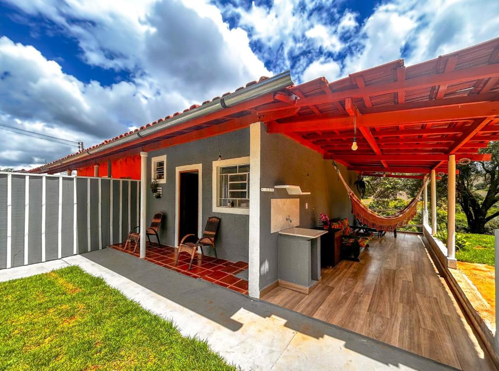 un patio de una casa con una pérgola roja en Casa confortavel com Wi-Fi em Braganca Paulista SP en Bragança Paulista