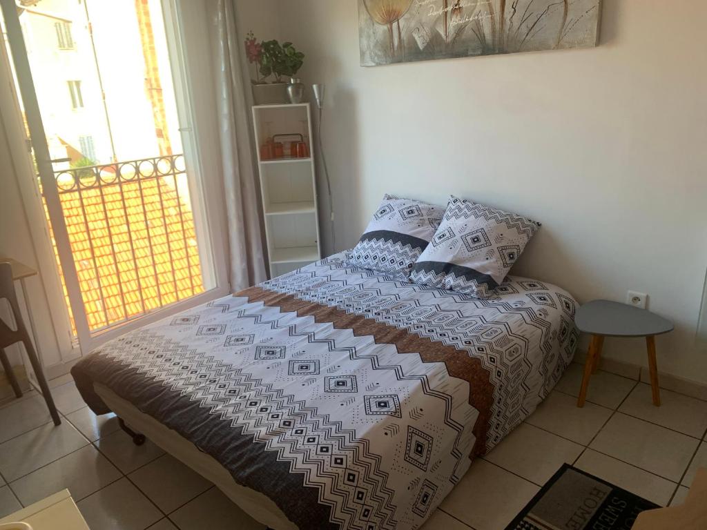 a bedroom with a bed in a room with a window at Duplex Raphael- Wi-fi et parking privé in Toulon