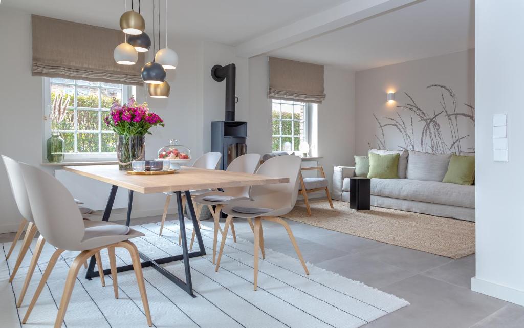 una sala da pranzo e un soggiorno con tavolo e sedie. di Haus Grüne Düne a Wenningstedt