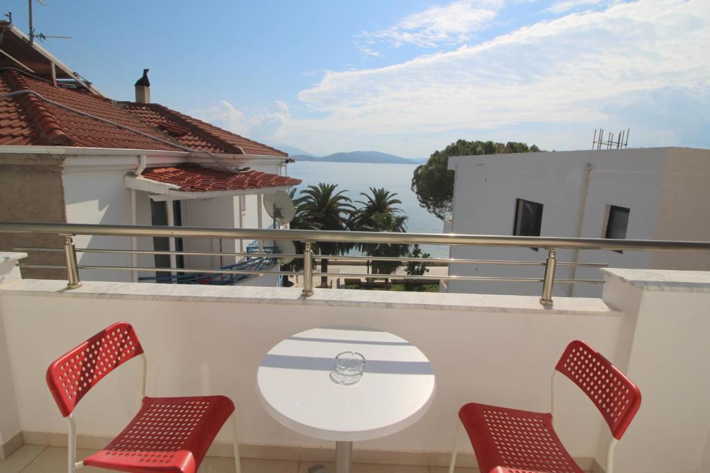 un tavolo e sedie su un balcone con vista sull'acqua di Elena Hotel a Sarandë