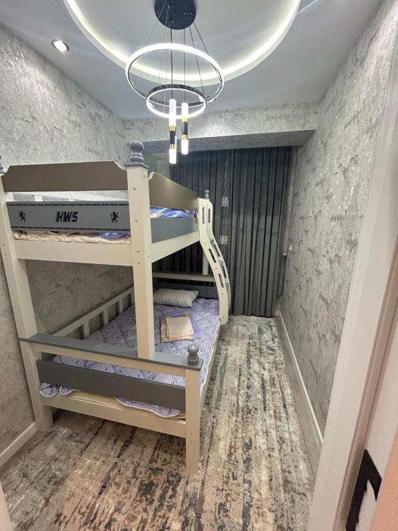 Apartment for tourists في سمرقند: سرير بطابقين في غرفة مع سقف