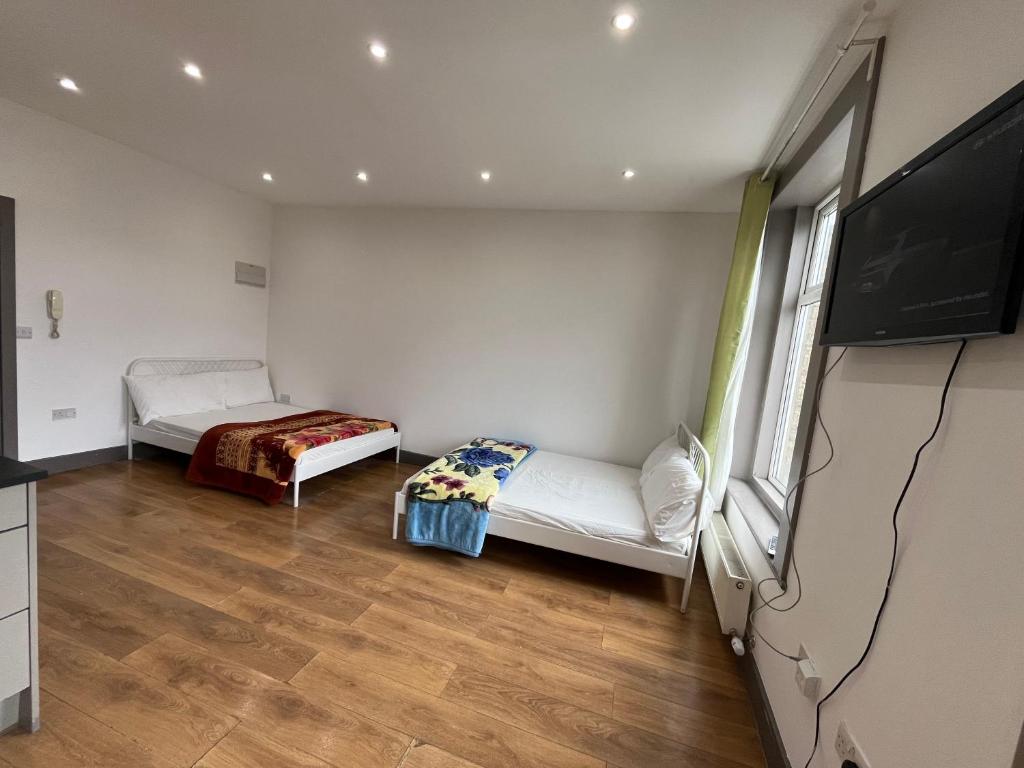 a room with two beds and a flat screen tv at Anerly Road in London