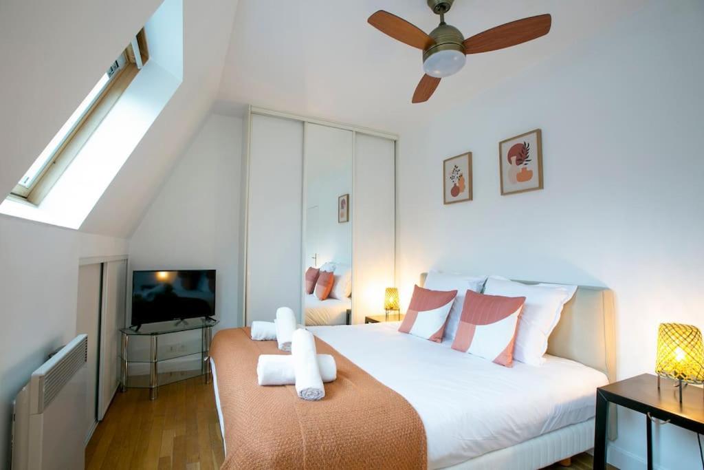 une chambre avec un grand lit avec un ventilateur de plafond dans l'établissement Skyline Parisian Flat - Exclusif Saint-Honoré, à Paris
