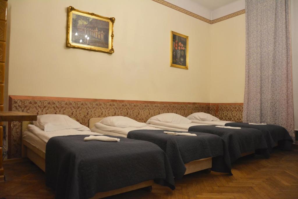 a group of four beds in a room at Florian Apartment 8 in Krakow