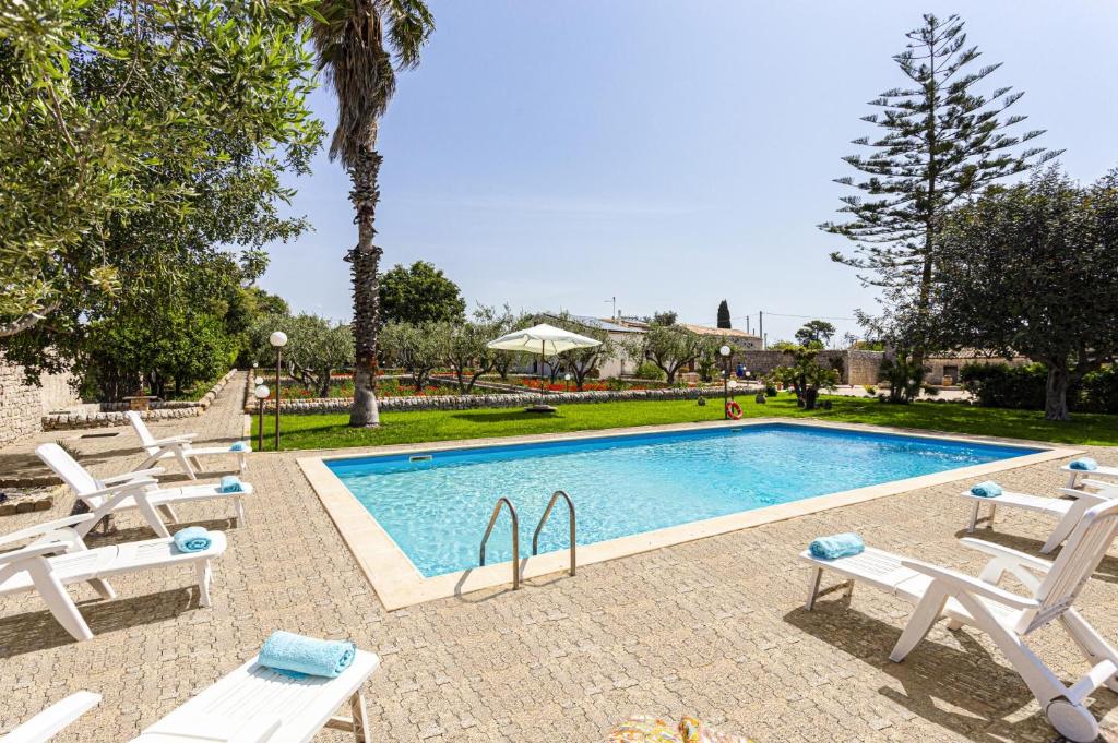 una piscina con tumbonas junto a un complejo en Villa Concetta by Villa Plus, en Módica