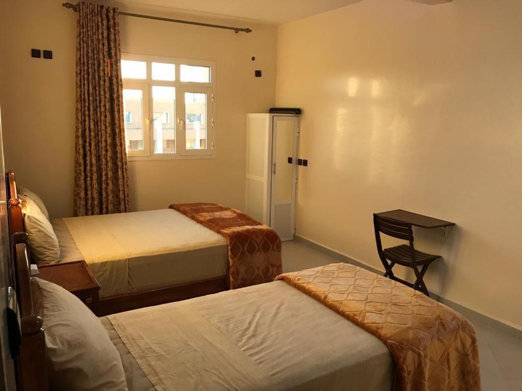 una camera d'albergo con due letti e una finestra di HOTEL TIZNIT AFOULKI a Tiznit