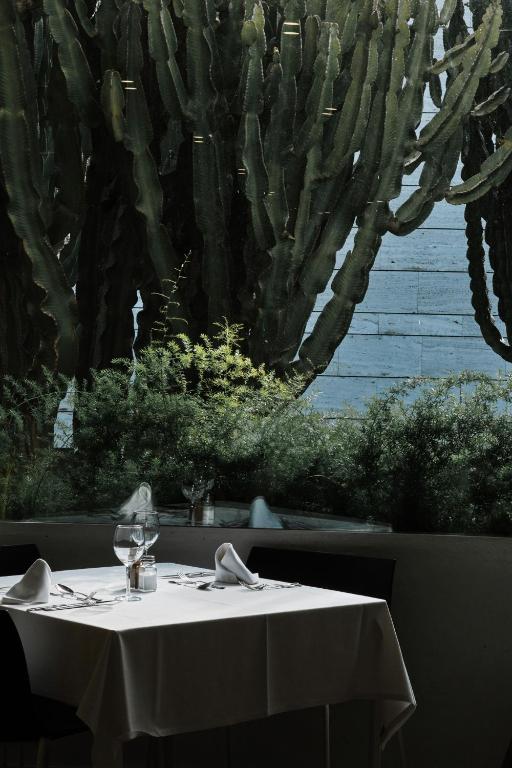 a table with a white table cloth on a table with a cactus at Prinsotel La Dorada & Spa in Playa de Muro