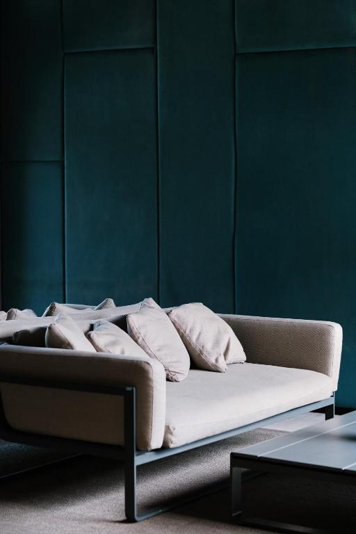 a couch in a room with a green wall at Prinsotel La Dorada & Spa in Playa de Muro
