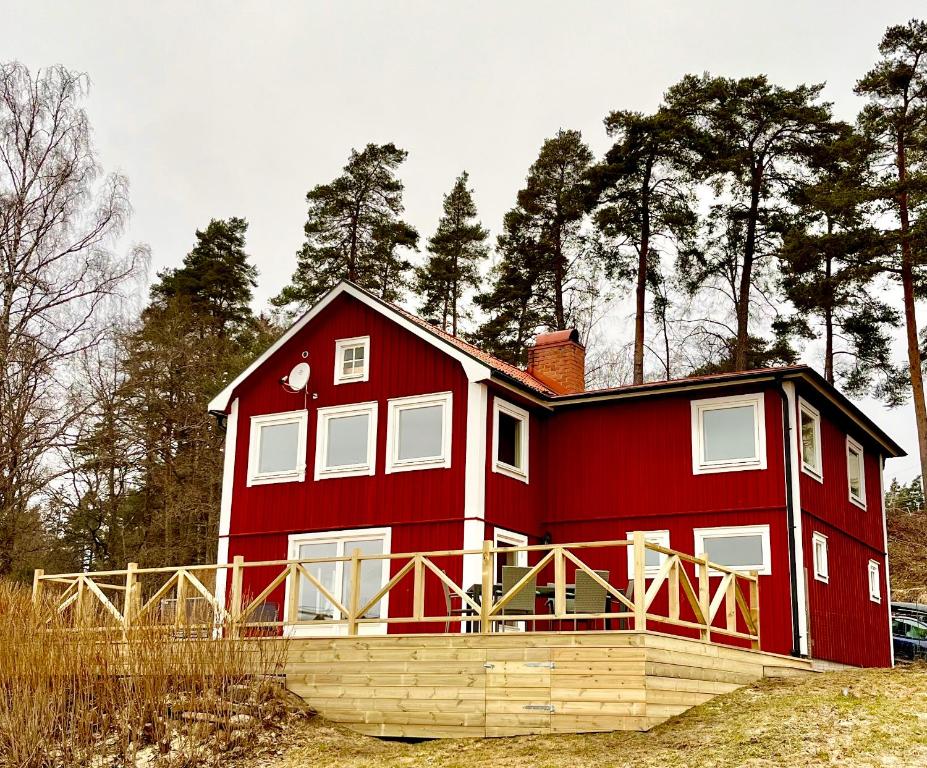 a red house in the middle of a field at Flemma Gård The lake view with sauna in Vreta Kloster