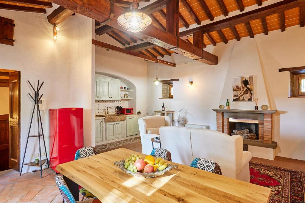 a kitchen and dining room with a table with a bowl of fruit at Casale Margherita in Cortona