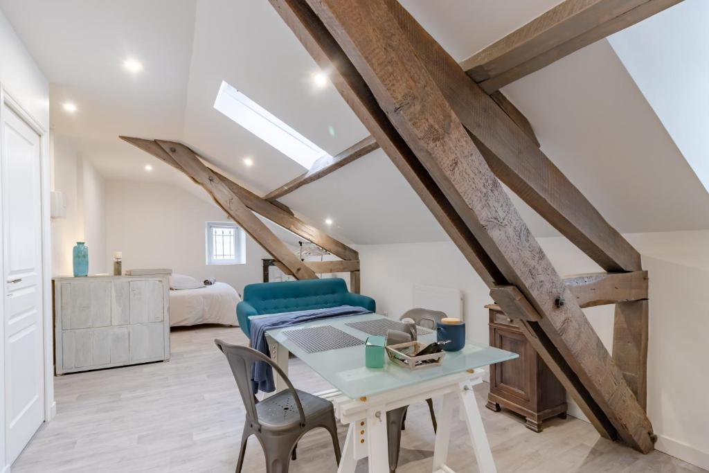 een keuken en een woonkamer met een tafel en stoelen bij D'am Chic Nomade Appartement bleu in Périgueux