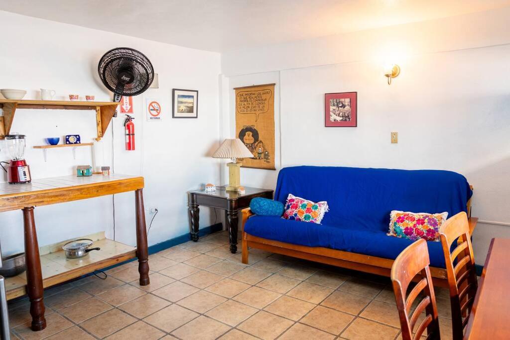 Beachfront Suite 5 Cacique في بييكيس: غرفة معيشة مع أريكة زرقاء وطاولة