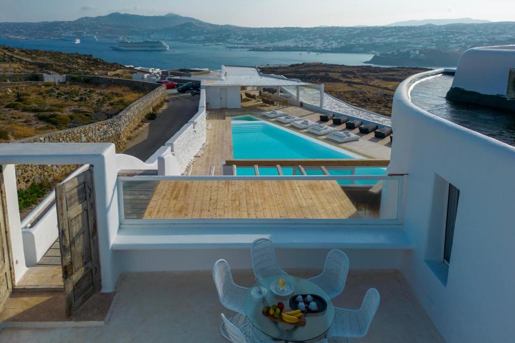 een uitzicht vanaf het balkon van een huis met een zwembad bij White Stone Mykonos in Agios Ioannis Mykonos